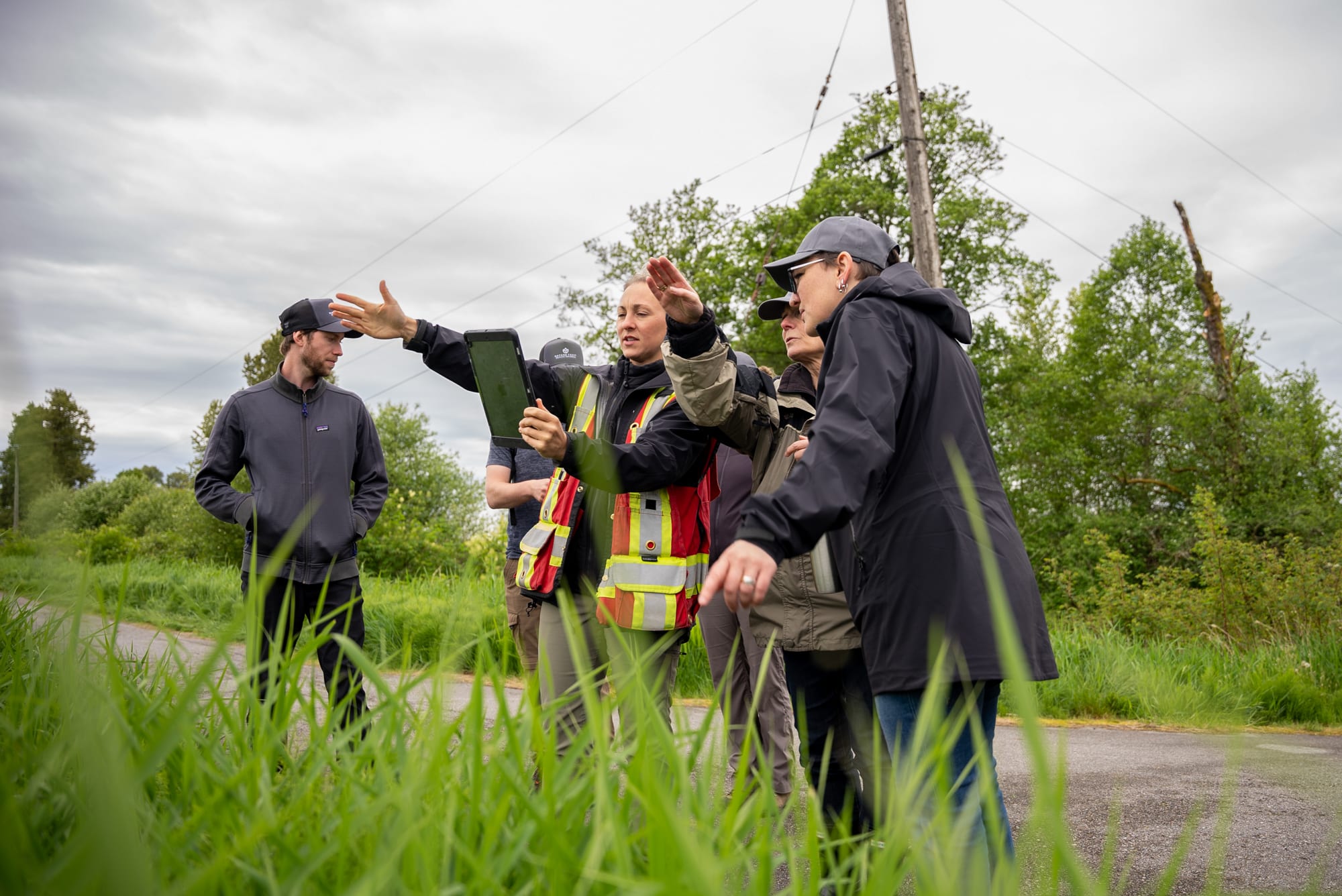 Sam Penner, Lower Mainland Field Operations Technician, examines the map with the team, pointing out landmarks to describe the property.